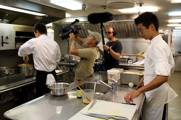 Doug Allan and Curig Huws filming the chefs busily preparing supper in the galley for the Golden Shadow Ship Tour video
