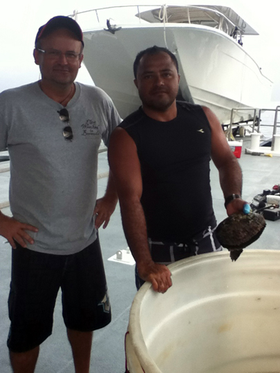Dr. Serge Andrefouet and Joseph cleaning the tanks holding pearl oysters for genetic and aquaculture projects