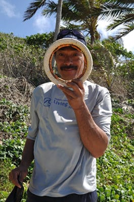 Beach litter: Hoifua’ Aholani holding up a photo of a tire found on the beach.