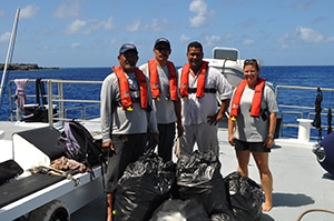 Education team members posing with beach litter they collected during the beach cleanup.