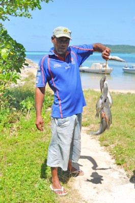 A Tongan fisherman holds up his catch from the morning.