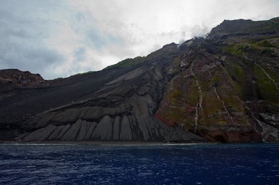 Steep ash and cinder slope from most recent Tinakula eruption terminates in black sand beach.