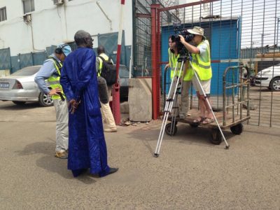 Cameraman Doug Allan filming fishermen selling their catch in the Port of Dakar