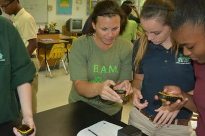 Prior to the fieldtrip, Amy Heemsoth, Director of Education teaches students how to use a GPS device.