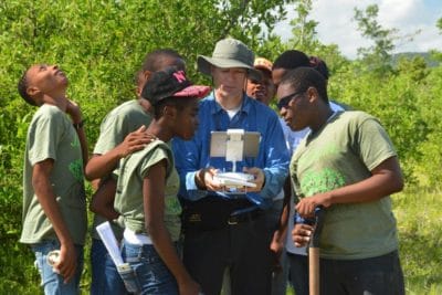 Students from William Knibb High School gather around Art Binkowski to get an aerial view the mangroves in Falmouth.