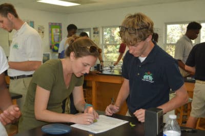 Ryann Rossi helps student at Forest Heights Academy to remove a small diseased portion of his mangrove leaf.