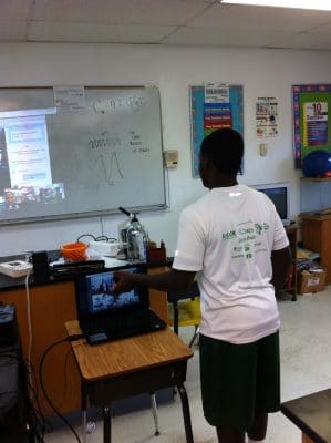 Forest Heights student discusses the fungi on his agar plate with Ryann who is on a video call with the class.
